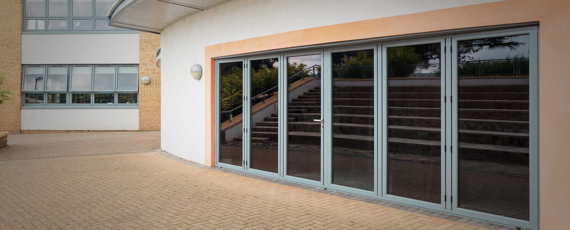 Grey aluminium sliding folding doors with a wide span