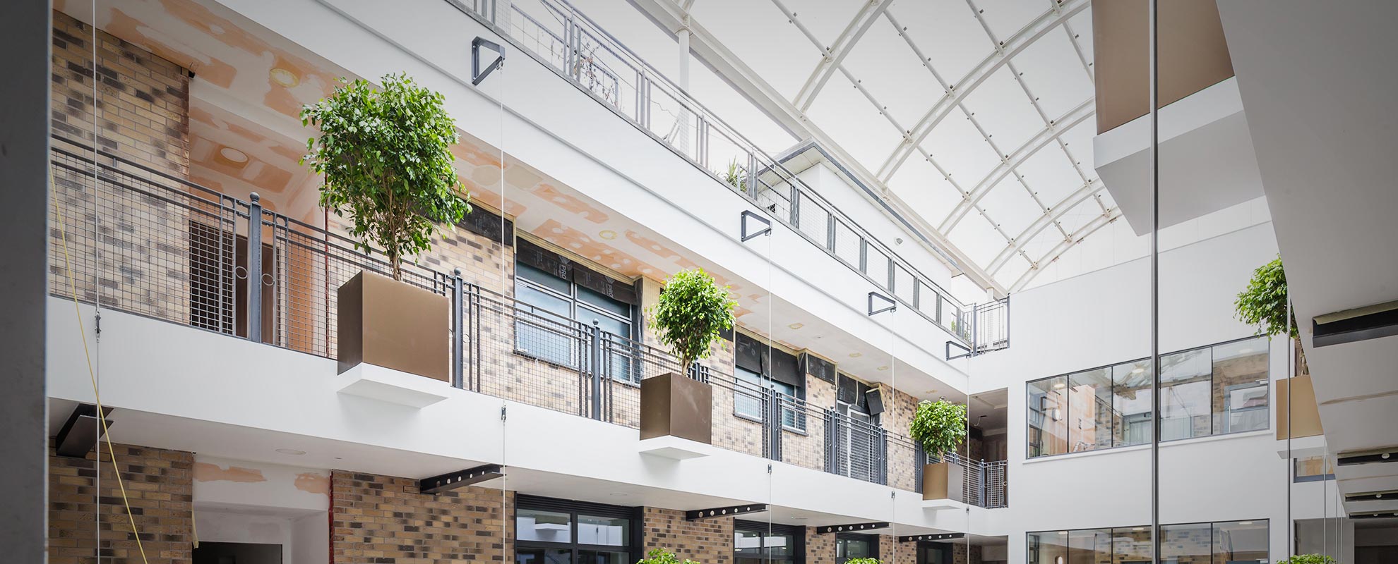 Large scale commercial atrium with fully glazed roof and aluminium windows and doors